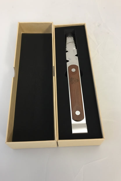A multi-tool with a silver metal body and a brown wooden handle, presented inside its open beige gift box with black foam insert.