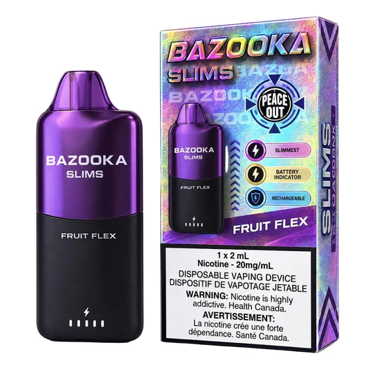 A blue Bazooka Slims disposable vaping device stands next to its retail box on a clean white background. The packaging is blue and white with 'BAZOOKA SLIMS' and 'BLUEBERRY POMEGRANATE' printed on it, plus a Peace Out badge and a nicotine warning label.